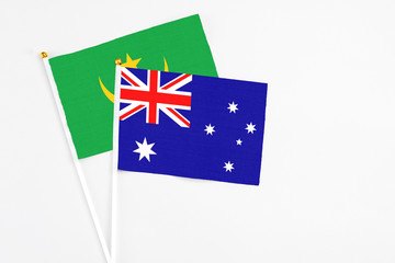 Fototapeta premium Australia and Mauritania stick flags on white background. High quality fabric, miniature national flag. Peaceful global concept.White floor for copy space.