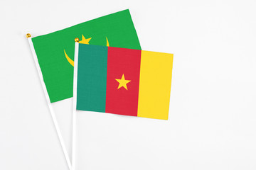 Cameroon and Mauritania stick flags on white background. High quality fabric, miniature national flag. Peaceful global concept.White floor for copy space.