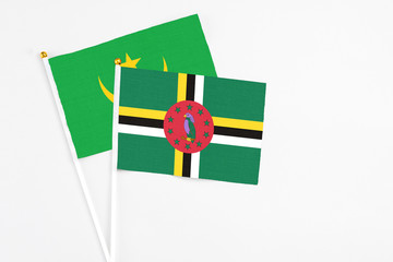Dominica and Mauritania stick flags on white background. High quality fabric, miniature national...