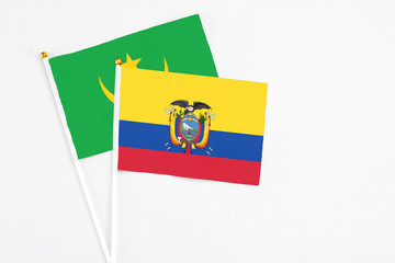 Ecuador and Mauritania stick flags on white background. High quality fabric, miniature national flag. Peaceful global concept.White floor for copy space.