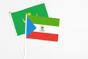 Equatorial Guinea and Mauritania stick flags on white background. High quality fabric, miniature national flag. Peaceful global concept.White floor for copy space.