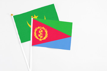 Eritrea and Mauritania stick flags on white background. High quality fabric, miniature national flag. Peaceful global concept.White floor for copy space.