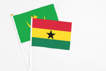 Ghana and Mauritania stick flags on white background. High quality fabric, miniature national flag. Peaceful global concept.White floor for copy space.