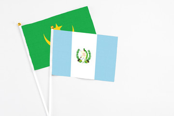 Guatemala and Mauritania stick flags on white background. High quality fabric, miniature national flag. Peaceful global concept.White floor for copy space.