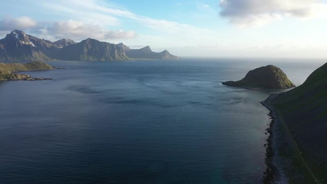 aerial view. flight over the sea,view on the Flakstadoya from Haukland beach and Mannen peak. Camera move forward .Lofoten Islands,Norway