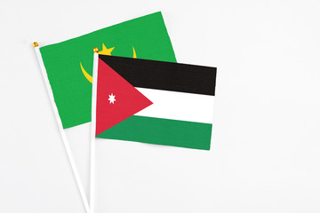 Jordan and Mauritania stick flags on white background. High quality fabric, miniature national flag. Peaceful global concept.White floor for copy space.