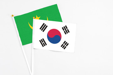 South Korea and Mauritania stick flags on white background. High quality fabric, miniature national flag. Peaceful global concept.White floor for copy space.