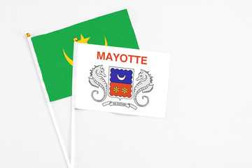 Mayotte and Mauritania stick flags on white background. High quality fabric, miniature national flag. Peaceful global concept.White floor for copy space.
