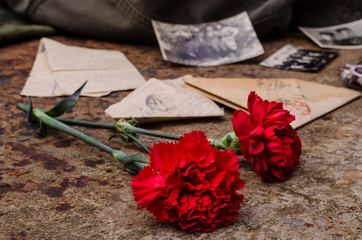 Victory Day. Carnations on a background of rusty iron with old military letters and photographs....