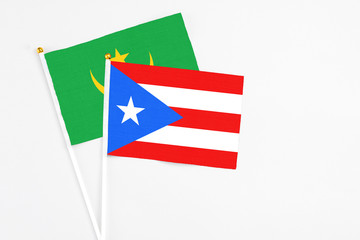 Puerto Rico and Mauritania stick flags on white background. High quality fabric, miniature national flag. Peaceful global concept.White floor for copy space.