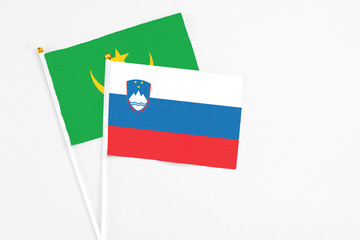 Slovenia and Mauritania stick flags on white background. High quality fabric, miniature national flag. Peaceful global concept.White floor for copy space.