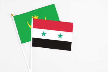 Syria and Mauritania stick flags on white background. High quality fabric, miniature national flag. Peaceful global concept.White floor for copy space.