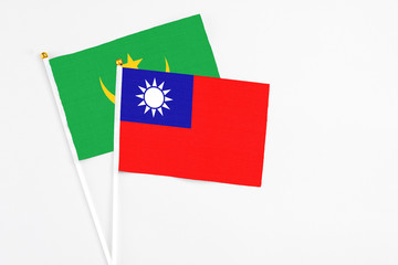 Taiwan and Mauritania stick flags on white background. High quality fabric, miniature national flag. Peaceful global concept.White floor for copy space.