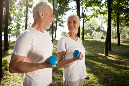 Cheerful couple with hand weights looking at each other stock photo