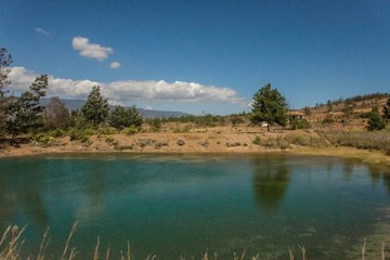 Blue lake surrounded by trees and blue sky