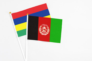 Afghanistan and Mauritius stick flags on white background. High quality fabric, miniature national...