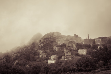 Fototapeta na wymiar Village of Speloncato in Corsica shrouded in mist