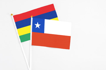 Chile and Mauritius stick flags on white background. High quality fabric, miniature national flag. Peaceful global concept.White floor for copy space.