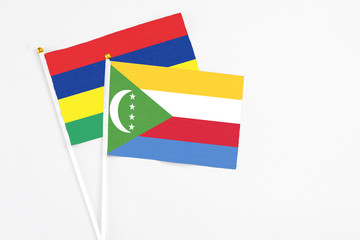 Comoros and Mauritius stick flags on white background. High quality fabric, miniature national...