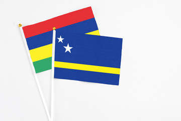 Curacao and Mauritius stick flags on white background. High quality fabric, miniature national flag. Peaceful global concept.White floor for copy space.