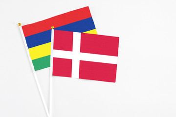 Denmark and Mauritius stick flags on white background. High quality fabric, miniature national flag. Peaceful global concept.White floor for copy space.