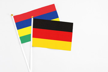 Germany and Mauritius stick flags on white background. High quality fabric, miniature national flag. Peaceful global concept.White floor for copy space.