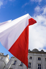 Polish red and white flags in the Old town in front of the building on a Sunny day.May 1, November...