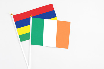 Ireland and Mauritius stick flags on white background. High quality fabric, miniature national flag. Peaceful global concept.White floor for copy space.