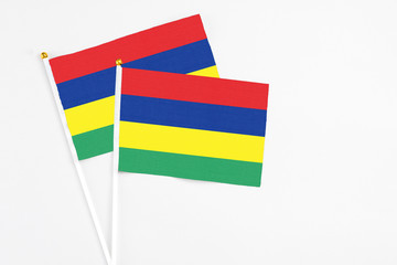 Mauritius and Mauritius stick flags on white background. High quality fabric, miniature national flag. Peaceful global concept.White floor for copy space.