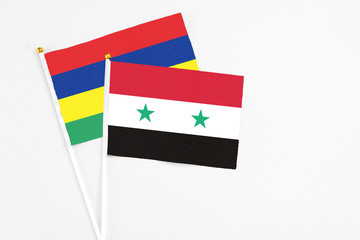 Syria and Mauritius stick flags on white background. High quality fabric, miniature national flag. Peaceful global concept.White floor for copy space.