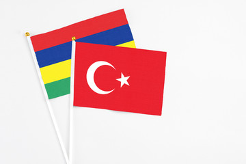 Turkey and Mauritius stick flags on white background. High quality fabric, miniature national flag. Peaceful global concept.White floor for copy space.