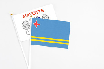 Aruba and Mayotte stick flags on white background. High quality fabric, miniature national flag. Peaceful global concept.White floor for copy space.