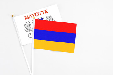 Armenia and Mayotte stick flags on white background. High quality fabric, miniature national flag. Peaceful global concept.White floor for copy space.