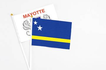 Curacao and Mayotte stick flags on white background. High quality fabric, miniature national flag. Peaceful global concept.White floor for copy space.