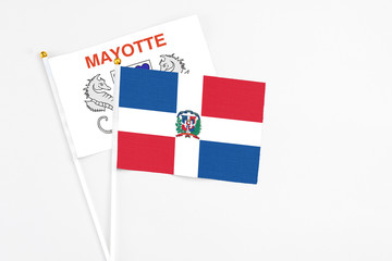 Dominican Republic and Mayotte stick flags on white background. High quality fabric, miniature national flag. Peaceful global concept.White floor for copy space.