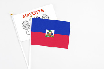 Haiti and Mayotte stick flags on white background. High quality fabric, miniature national flag....