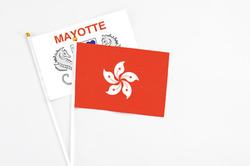 Hong Kong and Mayotte stick flags on white background. High quality fabric, miniature national flag. Peaceful global concept.White floor for copy space.
