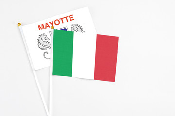 Italy and Mayotte stick flags on white background. High quality fabric, miniature national flag. Peaceful global concept.White floor for copy space.