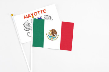 Mexico and Mayotte stick flags on white background. High quality fabric, miniature national flag. Peaceful global concept.White floor for copy space.