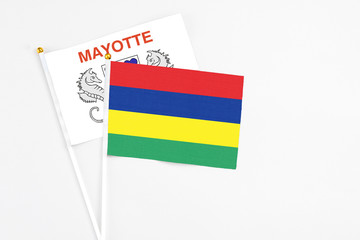 Mauritius and Mayotte stick flags on white background. High quality fabric, miniature national flag. Peaceful global concept.White floor for copy space.