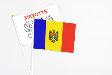 Moldova and Mayotte stick flags on white background. High quality fabric, miniature national flag. Peaceful global concept.White floor for copy space.