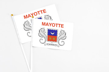 Mayotte and Mayotte stick flags on white background. High quality fabric, miniature national flag. Peaceful global concept.White floor for copy space.