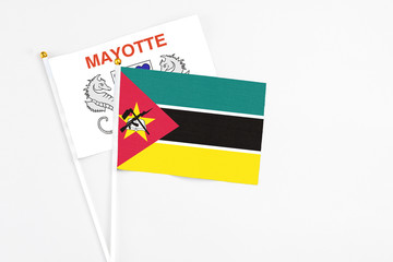 Mozambique and Mayotte stick flags on white background. High quality fabric, miniature national flag. Peaceful global concept.White floor for copy space.