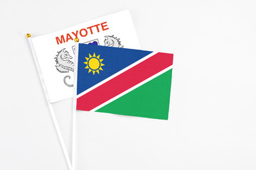 Namibia and Mayotte stick flags on white background. High quality fabric, miniature national flag. Peaceful global concept.White floor for copy space.