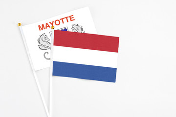 Netherlands and Mayotte stick flags on white background. High quality fabric, miniature national flag. Peaceful global concept.White floor for copy space.