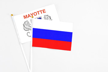 Russia and Mayotte stick flags on white background. High quality fabric, miniature national flag. Peaceful global concept.White floor for copy space.