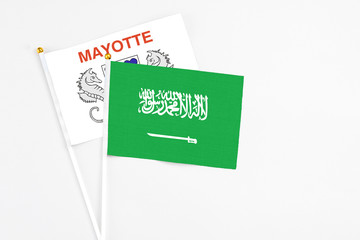 Saudi Arabia and Mayotte stick flags on white background. High quality fabric, miniature national flag. Peaceful global concept.White floor for copy space.