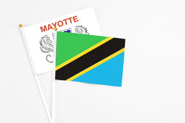 Tanzania and Mayotte stick flags on white background. High quality fabric, miniature national flag. Peaceful global concept.White floor for copy space.