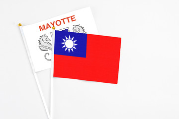 Taiwan and Mayotte stick flags on white background. High quality fabric, miniature national flag. Peaceful global concept.White floor for copy space.