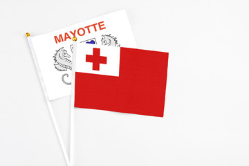 Tonga and Mayotte stick flags on white background. High quality fabric, miniature national flag. Peaceful global concept.White floor for copy space.